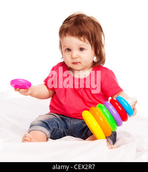 niedliche Baby spielen mit Spielzeug und machen eine Pyramide auf dem Boden Stockfoto