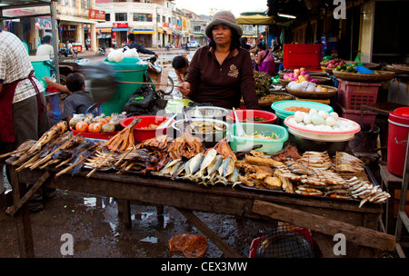 Ein Kreditor scheuchte fliegen hinter einem gebratenen und geräucherten Fisch Stall in Kratie, Kambodscha Stockfoto