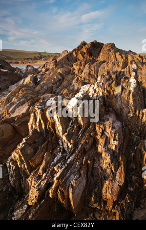 Zerklüftete Felsformationen, beleuchtet durch goldene Abend Sonnenlicht am Bantham Strand, Devon, England. Stockfoto