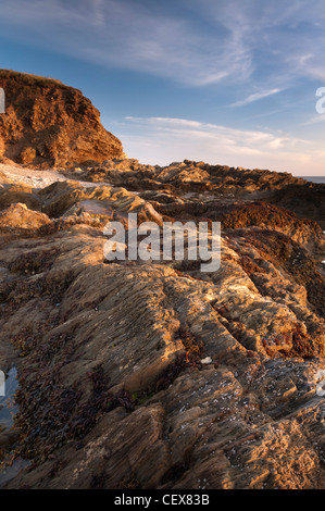 Zerklüftete Felsformationen, beleuchtet durch goldene Abend Sonnenlicht am Bantham Strand, Devon, August 2011. Stockfoto