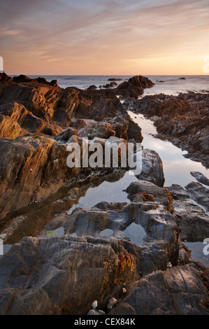 Zerklüftete Felsformationen, beleuchtet durch goldene Abend Sonnenlicht am Bantham Strand, Devon, August 2011. Stockfoto