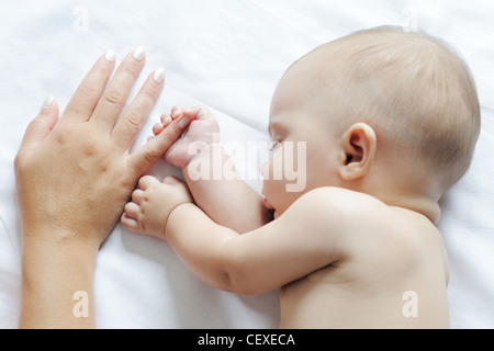 Baby schläft in der Nähe ihrer Mutter, mit ihrem finger Stockfoto