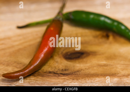 Rote und grüne Chilischoten auf Holzbrett Stockfoto