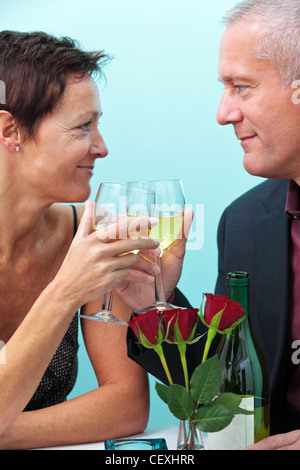 Foto von ältere Ehepaar hält Gläser Wein und sahen einander, während in einem Restaurant saßen. Stockfoto