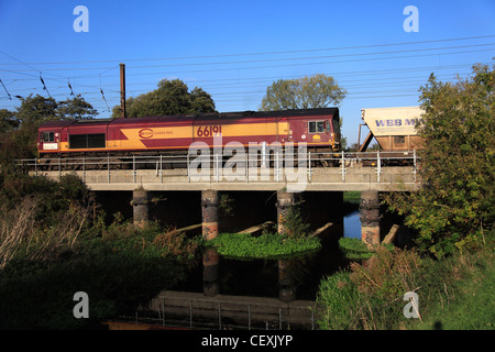 EWS 66191 Diesel angetrieben Güterzug, ziehen Container, East Coast Main Line Railway, Cambridgeshire, England, UK Stockfoto