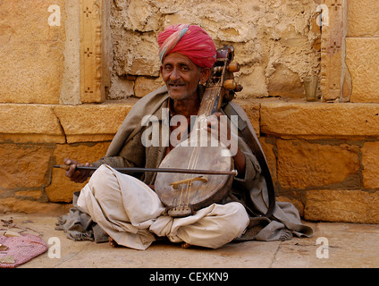 Senior Rajput Mann Straßenmusik fröhlich rezitierten Musik spielen einerseits gemacht Violine "Vina" unterhaltsame öffentliche Straße um Spenden. Stockfoto