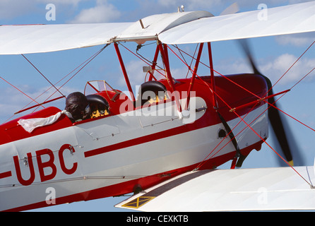 Nahaufnahme, pilot mit Lederhelm und einen weißen Schal flattern im Wind an Bord von einem Oldtimer Doppeldecker Tiger Moth De Haviland DH 82A (Buit 1938) Stockfoto