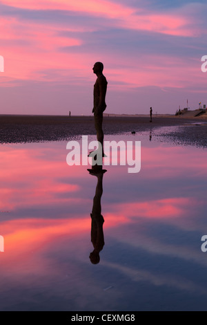 Antony Gormley Statue silhouettiert, Twilight, ein weiterer Ort Crosby. Stockfoto