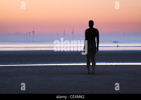 Antony Gormley Statue silhouettiert, Twilight, ein weiterer Ort Crosby. Stockfoto