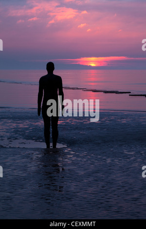 Antony Gormley Statue der Silhouette.  Sonnenuntergang, ein weiterer Ort Crosby. Stockfoto