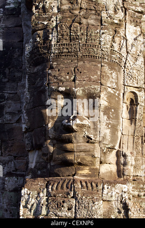 Eines der markantesten Merkmale der Bayon, einen massiven steinernen Gesicht im frühen Morgenlicht innerhalb des Komplexes von Angkor Thom Stockfoto