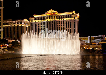 Der Wasser-Lightshow im Bellagio in Las Vegas Nevada mit Caesars Palace und den Streifen im Hintergrund Stockfoto