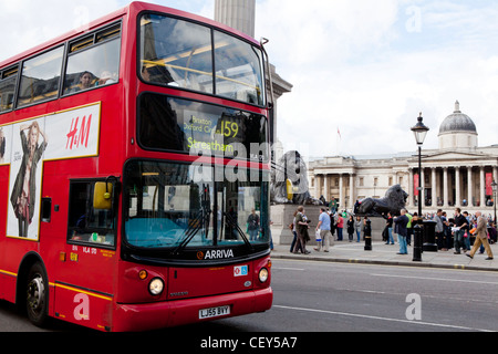 Ein Blick auf einem roten Bus als es passiert vor der nationalen Portrait-Galerie und Nelson Säule am Trafalgar Square Stockfoto