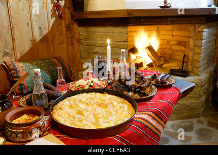 Traditionelle bulgarische Speisen am Tisch vor einem Kamin Stockfoto