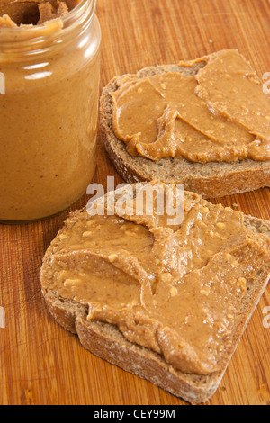 Bild von zwei Scheiben Brot mit Erdnussbutter und ein Glas Erdnussbutter Stockfoto