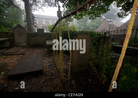 Nebligen Morgen in Haworth Kirchhof wird Bronte Parsonage im Hintergrund. Stockfoto