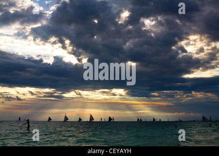 Sonnenuntergang bricht durch die Wolken und leuchtet am Horizont in Boracay, Aklan Province, Philippinen. Stockfoto