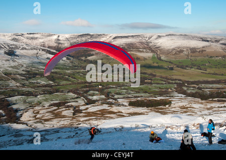 Ein Gleitschirm starten ab Rushup Rand, Edale, Peak District, Derbyshire, England, UK.  Die Kinder Scout Plateau hinter. Stockfoto