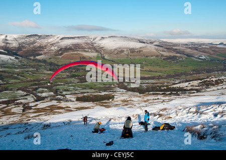 Ein Gleitschirm starten ab Rushup Rand, Edale, Peak District, Derbyshire, England, UK.  Die Kinder Scout Plateau hinter. Stockfoto