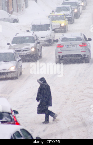 Autos und Fußgänger in Blizzard während gefangen Kälteeinbruch in Osteuropa, Februar 2012. Stockfoto