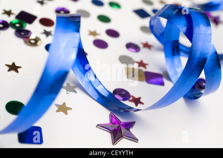 Ein Stillleben Bild von bunten Konfetti und blauen Streamer auf weißem Hintergrund Stockfoto