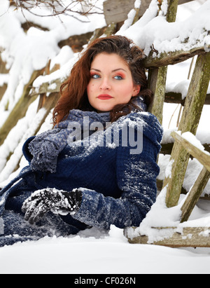 Porträt einer schönen 20 jährige Frau sitzen im Schnee im Winter. Stockfoto