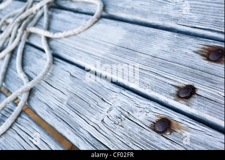 alte Holzbretter und rostigen Nägeln mit einem Seil auf Stockfoto