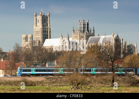 Ein Schuß aus der ganzen Fens von Ely Kathedrale mit Zug passiert. Ely, Cambridgeshire, England. Stockfoto