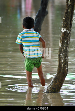 Kinder waten durch Hochwasser in der Nähe von Siem Reap, Kambodscha Stockfoto