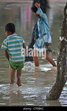 Kinder waten durch Hochwasser in der Nähe von Siem Reap, Kambodscha Stockfoto