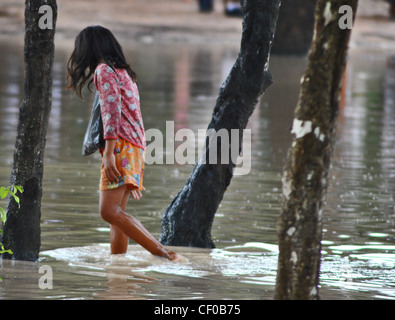 Kinder waten durch Hochwasser in der Nähe von Siem Reap, Kambodscha Stockfoto