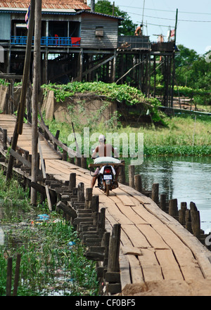 Ein Motorrad überquert eine Brücke in Kompong Khleang Dorf, Tonle Sap, Kambodscha Stockfoto