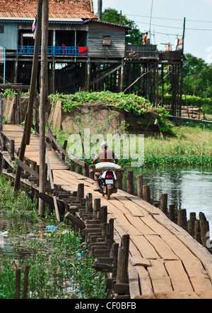 Ein Motorrad überquert eine Brücke in Kompong Khleang Dorf, Tonle Sap, Kambodscha Stockfoto