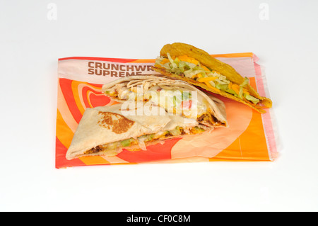 Taco Bell Crunchwrap oberste Tortilla in zwei Hälften geschnitten und ein Taco auf Wrapper auf weißem Hintergrund Ausschnitt Stockfoto