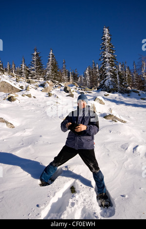 Kletterer auf Schneeschuhen (Schneeschuhe) an den Berghang. Winterwald. Russland. Ural-Gebirge. Nationalpark Taganay. Stockfoto