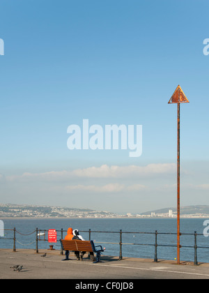 Ein paar Blick auf das Meer an der Promenade, Mumbles, Wales Stockfoto