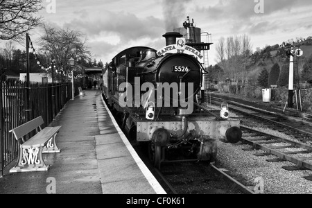 Eine Landschaft in schwarz und weiß von einem Dampfzug wartet am Bahnhof gedreht. Stockfoto