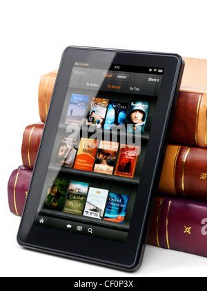 Amazon Kindle Fire Tablet Ebuch lehnte sich gegen einen Haufen von Hardcover-Büchern. Isoliert auf weißem Hintergrund. Stockfoto