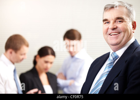 Porträt eines fröhlichen reifer Geschäftsmann lächelnd und Blick in die Kamera Stockfoto