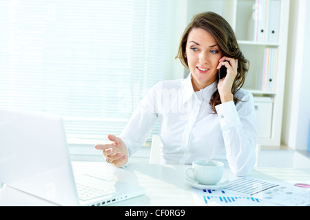 Junge Geschäftsfrau, die Teilnahme an Telefongespräch mit einem Kunden Stockfoto