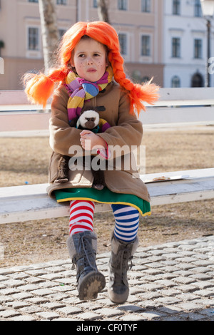 Kleines Mädchen gekleidet wie Pippi lang Strumpf sitzen auf einer Bank im Park. Stockfoto