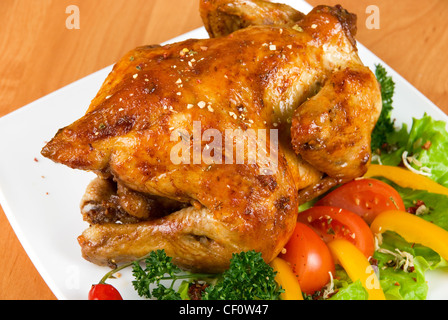 Gebratenes Huhn, garniert mit frischen Tomaten, grüner Salat, Paprika und grünen Stockfoto