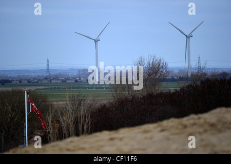Windkraftanlagen in Norden von Camber Sands an der Küste von East Sussex, gesehen auf roten Ziegel Dächer in der Nähe von Roggen. Stockfoto