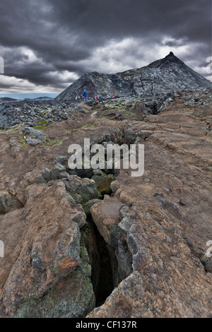 Risse in Lavafelder mit Menschen wandern, Island Stockfoto