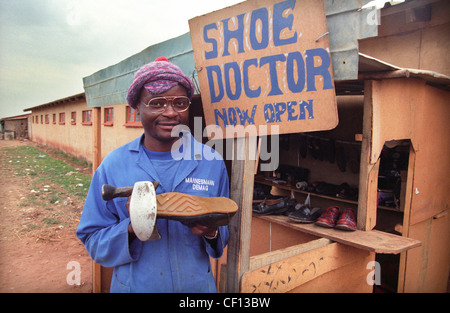 Eine südafrikanische "Schuh Doctor" auf seine Schuhreparatur stall in Soweto in 1996. Stockfoto