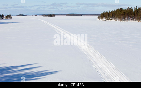 Luftaufnahme einer Schneemobil-Route auf Seeeis im Winter, Finnland Stockfoto