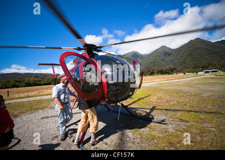 Menschen Sie verlassen Berg Helikopter in Fox Glacier Stadt, Südalpen, Südinsel, Neuseeland. Stockfoto