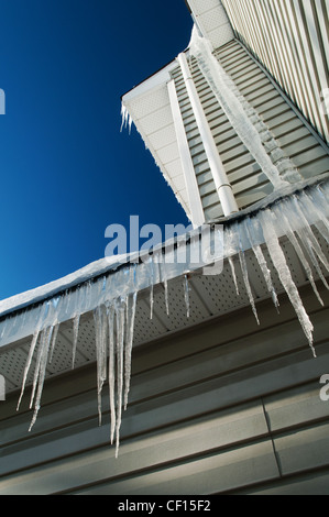 Gefrorenen Eiszapfen hängen von einem Wohngebäude im Winter. Stockfoto