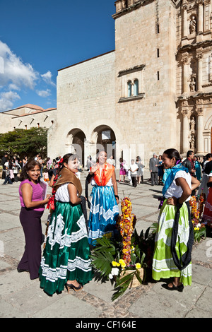 drei indigenen mexikanischen Inderinnen Tänzer in bunten traditionellen Kleid entspannend auf Kirche Plaza nach dem Tanzen in einer Prozession Stockfoto