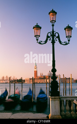 Ein Blick auf die Kirche von San Giorgio mit Gondeln und einer traditionellen Straßenlaterne in der frühen Morgensonne. Stockfoto